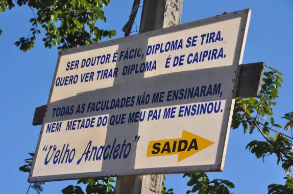 Sabedoria popular em placa na saída do povoado de Orominas, região de Nova Roma - GO
